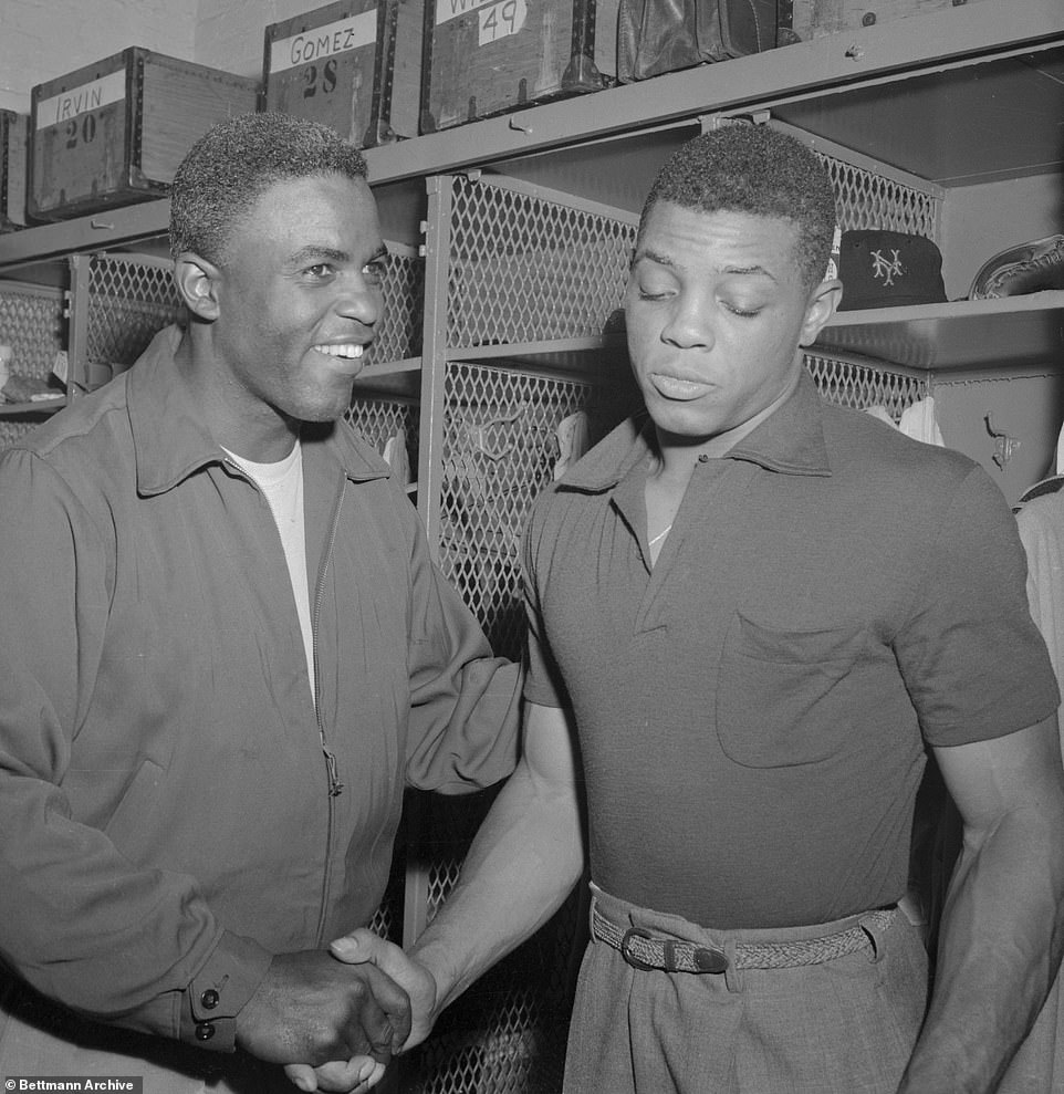 Willie Mays (R) of the New York Giants accepts the congratulations of Brooklyn Dodger veteran Jackie Robinson