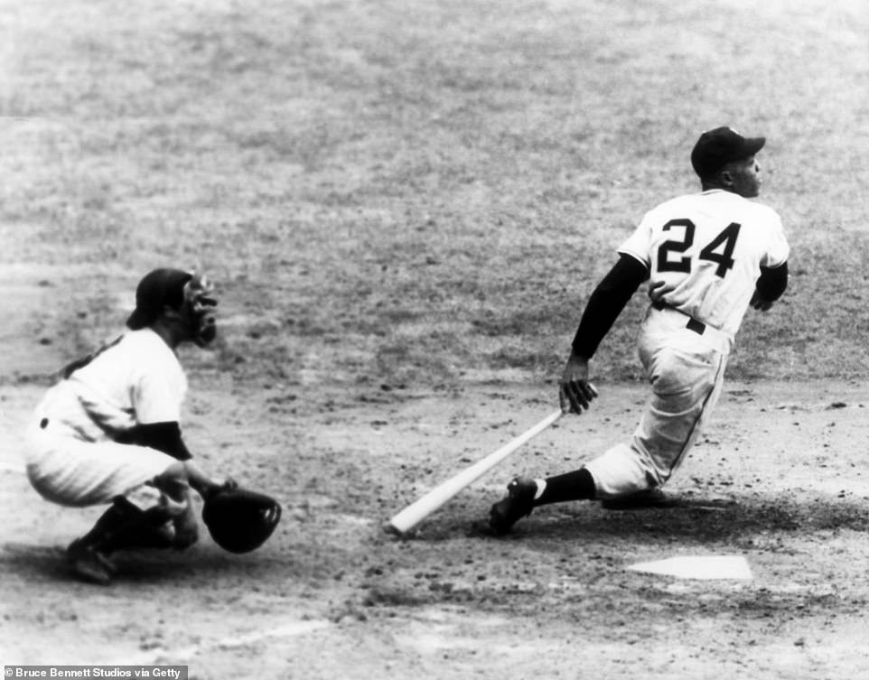 Willie Mays swings at the pitch as catcher Yogi Berra  sets up behind home plate during Game 1 of the 1951 World Series