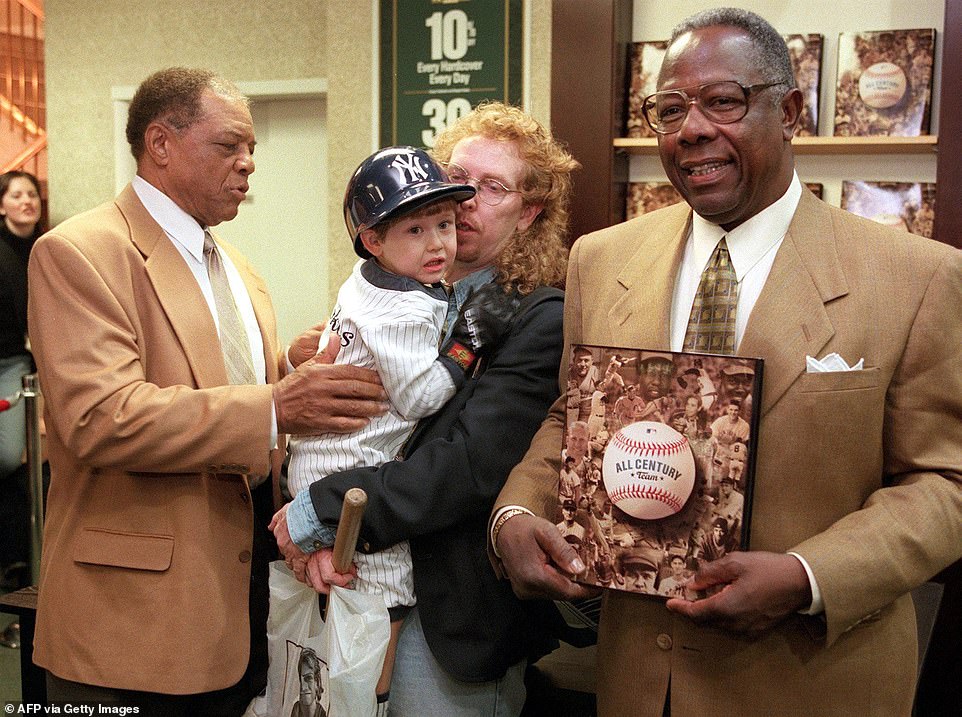 Willie Mays (L) and Hank Aaron (R) pose with a shy Joshua Bence, 3, and Randy Bence before a book signing in 199