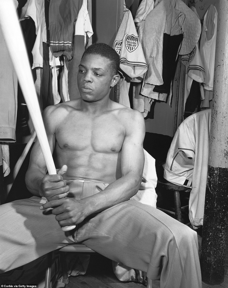 Willie Mays sits holding a baseball bat in the clubhouse of the Minneapolis Millers on May 19th, 1951