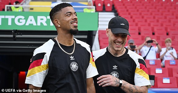 STUTTGART, GERMANY - JUNE 19: Benjamin Henrichs of Germany speaks with David Raum as they walk out of the tunnel to inspect the pitch prior to the UEFA EURO 2024 group stage match between Germany and Hungary at Stuttgart Arena on June 19, 2024 in Stuttgart, Germany. (Photo by Chris Ricco - UEFA/UEFA via Getty Images)