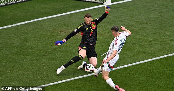 Germany's goalkeeper #01 Manuel Neuer prevents Hungary's forward #20 Roland Sallai from scoring during the UEFA Euro 2024 Group A football match between Germany and Hungary at the Stuttgart Arena in Stuttgart on June 19, 2024. (Photo by Fabrice COFFRINI / AFP) (Photo by FABRICE COFFRINI/AFP via Getty Images)