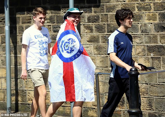 An England fan with a Rochdale flag as he heads to the pub in Leeds today to watch the game