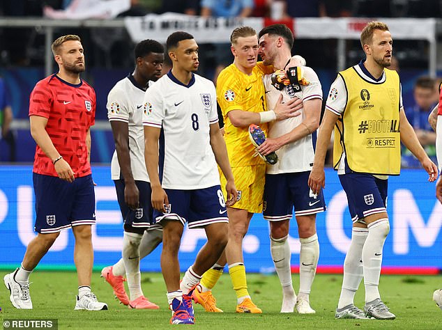 Dejected members of the England squad walk off at full-time after a disappointing performance