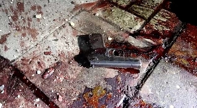 A police issue handgun is seen lying on a bloodstained pavement in Dagestan following the attacks