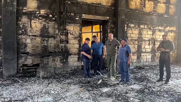 In this photo taken from video released by The Telegram Channel of the head of Dagestan Republic of Russia on Monday, June 24, 2024, the head of Dagestan Republic Sergei Melikov, center, visits the damaged the Kele-Numaz synagogue in Derbent after a counter-terrorist operation in republic of Dagestan, Russia