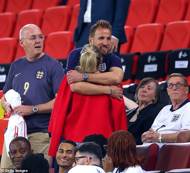 Harry Kane embraces wife Katie Goodland in the stands, following the team's draw against Slovenia