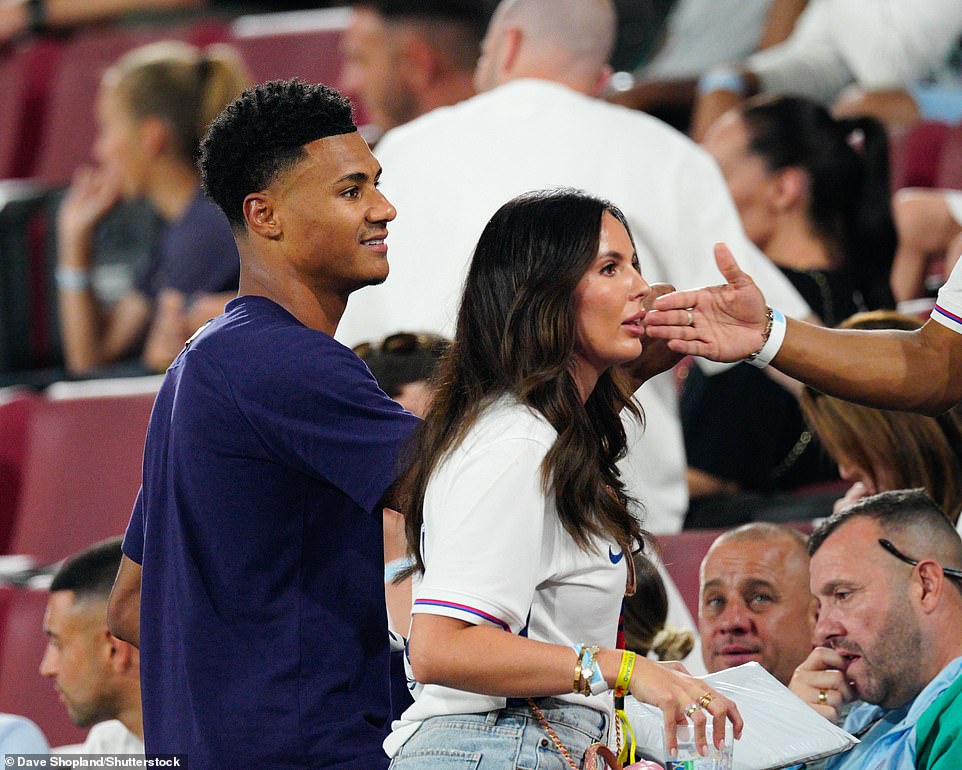 Ollie Wilkins was greeted with a kiss from his long-term girlfriend Ellie Anderson in the stands, while Harry Kane beamed as he gave his wife a huge bear hug and draped a red jacket over her shoulders.