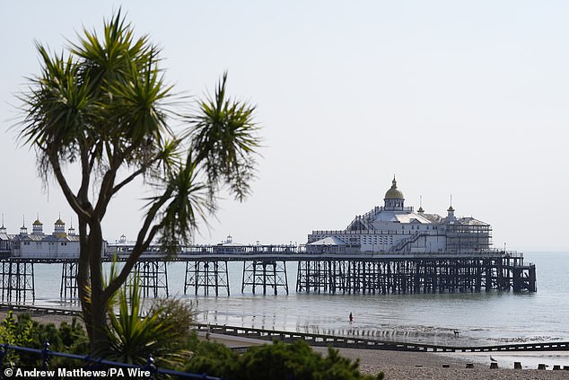 A person enters the sea by Eastbourne Pier in East Sussex this morning
