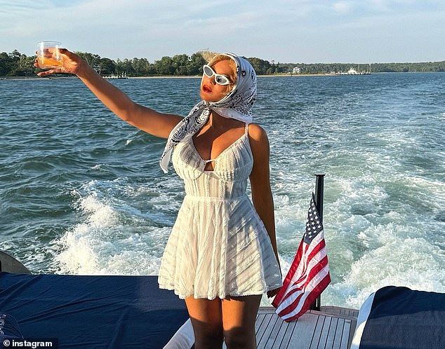 The TEXAS HOLD 'EM hitmaker donned a very low cut white lacy mini dress as she posed on the back of a luxury yacht