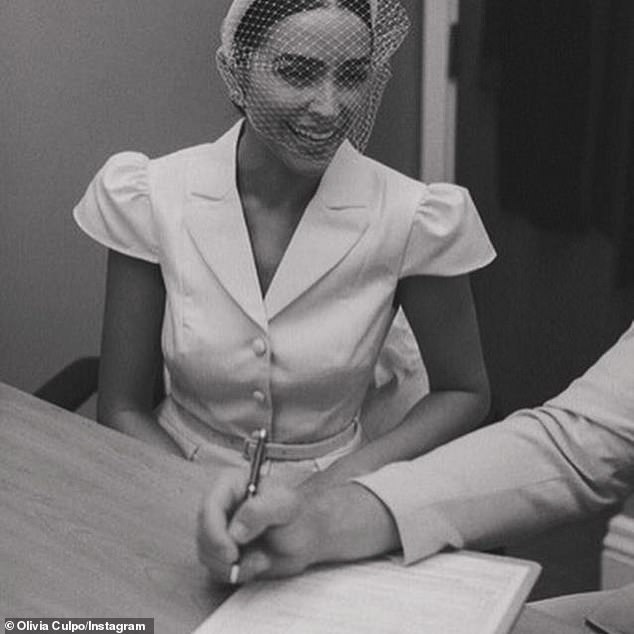 The model looked thrilled as she watched her new husband sign the license