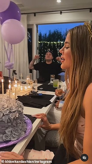 In footage from one birthday bash, Khloe was presented with a cake as her guests sang Happy Birthday To You - with a beaming Rob among them