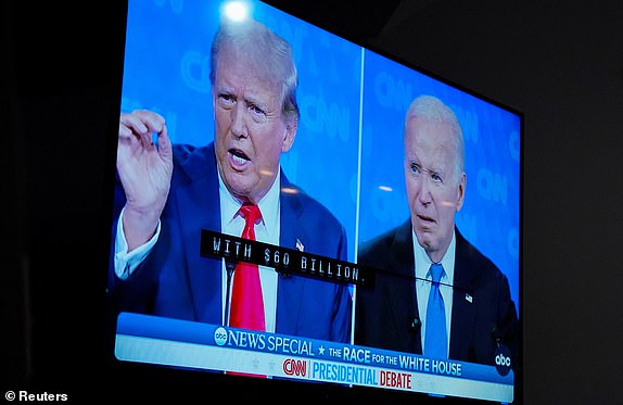 A TV screen shows the debate as The New Hanover County Democratic party hosts a watch party as U.S. President Joe Biden and former U.S. President Donald Trump face off in the first presidential debate of the 2024 election, in Wilmington, North Carolina, U.S. June 27, 2024.  REUTERS/Allison Joyce