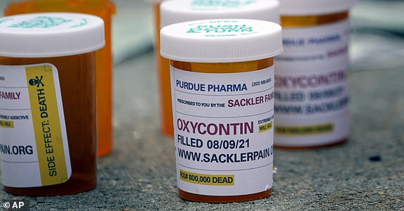 FILE - Fake pill bottles with messages about Purdue Pharma are displayed during a protest outside the courthouse where the bankruptcy of the company is taking place in White Plains, N.Y., Monday, Aug. 9, 2021. The Supreme Court on Thursday, June 27, 2024, rejected a nationwide settlement with OxyContin maker Purdue Pharma that would have shielded members of the Sackler family who own the company from civil lawsuits over the toll of opioids but also would have provided billions of dollars to combat the opioid epidemic.  (AP Photo/Seth Wenig, File)