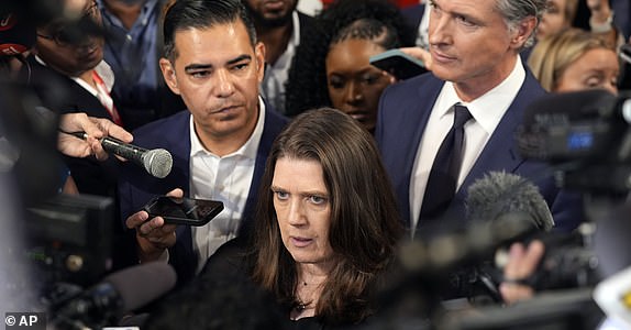 Mary Trump, niece of Republican presidential candidate former President Donald Trump speaks to reporters in the spin room after a presidential debate between President Joe Biden and Trump in Atlanta, Thursday, June 27, 2024, as Rep. Robert Garcia, D-Calif., and California Gov. Gavin Newsom, right, listen. (AP Photo/John Bazemore)