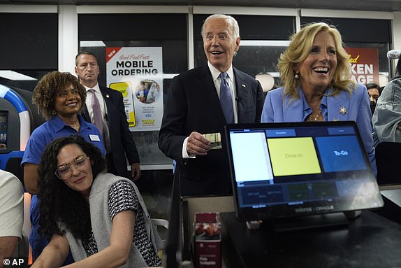 President Joe Biden, center, and first lady Jill Biden, right, pay for a purchase as they greet supporters at a Waffle House in Marietta, Ga., Friday, June 28, 2024, following a presidential debate in Atlanta. (AP Photo/Evan Vucci)