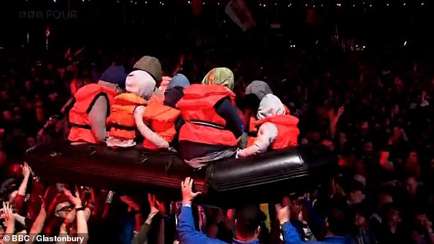 A blow-up small boat surfs the crowd during the performance by Idles at Glastonbury