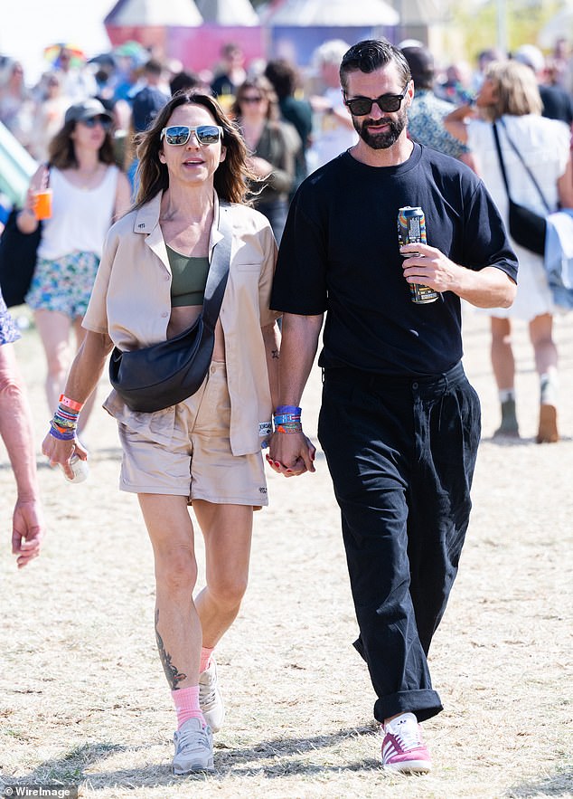 The pair looked happier than ever as they held hands while carrying drinks in the other as they made their way around the iconic Worthy Farm