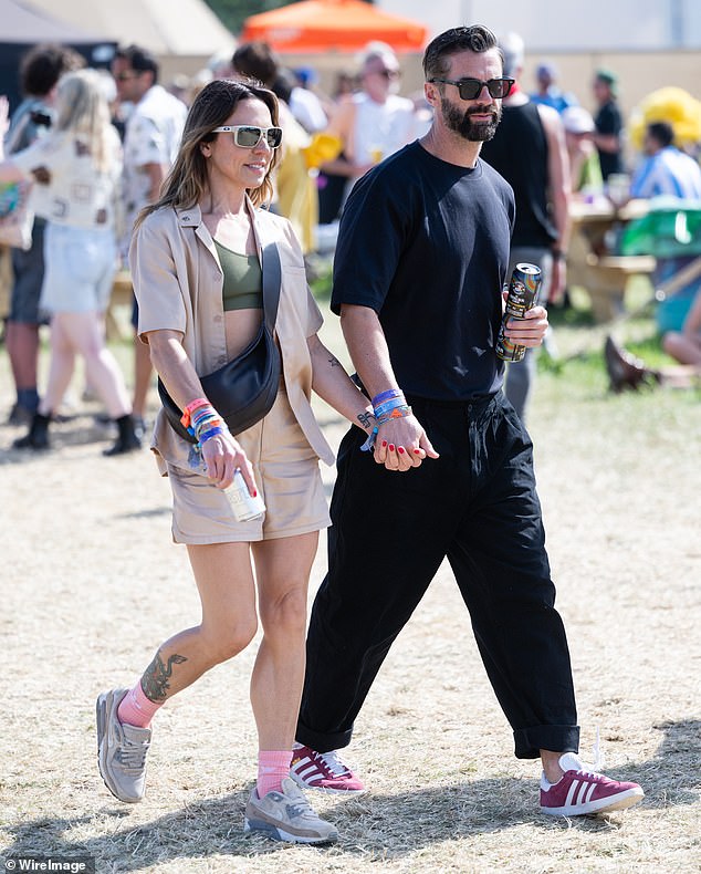 The Spice Girl, 50, cut a cool figure in an open beige shirt and short co-ord while her hunky companion rocked an all black outfit
