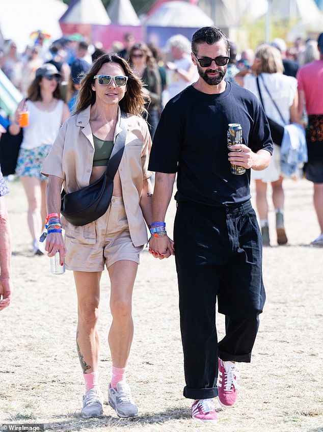 Mel C couldn't contain her smile as she walked hand-in-hand with a mystery man around Glastonbury Festival on Saturday