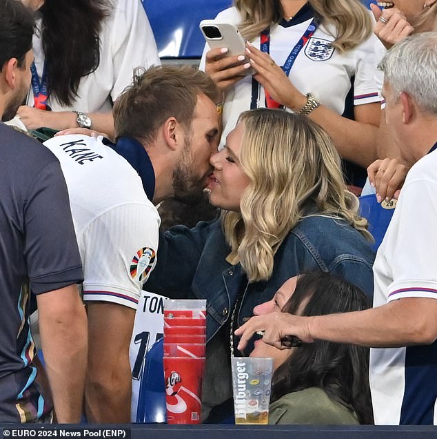 Kane gives his wife Katie Goodland a kiss as he celebrates England's win