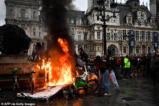 Protestors light a fire with electric bikes in front of the Hotel de Ville during a demonstration after France's Constitutional Council approved the key elements of French President's pension reform, in Paris on April 14, 2023