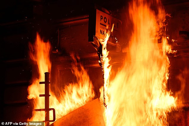 A photograph shows the frontage of a police station on fire during a demonstration, after France's Constitutional Council approved the key elements of French President's pension reform, in Rennes, western France, on April 14, 2023