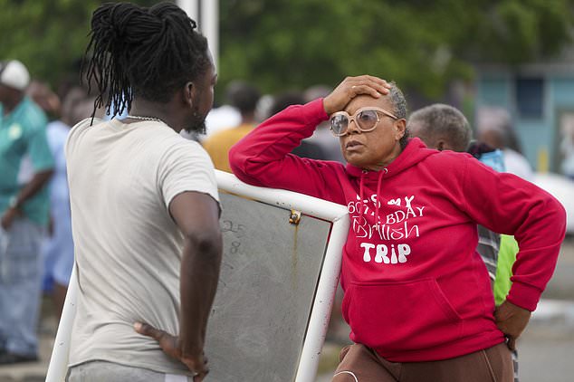 Sylvia Small, right, waits for police approval to enter the pier to check her boat's damages due to Hurricane Beryl at the Bridgetown Fisheries in Barbados (Ricardo Mazalan/AP)