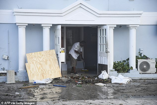 A man clears water from a damaged restaurant after the passage of Hurricane Beryl in in Hastings, Christ Church, Barbados, on July 1, 2024
