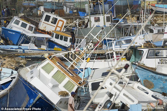 A fisherman looks at fishing vessels damaged by Hurricane Beryl at the Bridgetown Fisheries in Barbados, Monday, July 1, 2024. (AP Photo/Ricardo Mazalan)