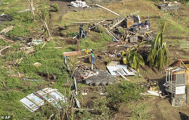Family members survey their home destroyed in the passing of Hurricane Beryl, in Ottley Hall, St. Vincent and the Grenadines, Tuesday, July 2