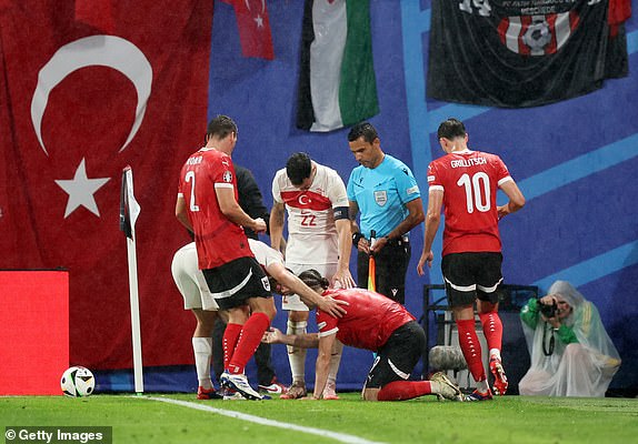 LEIPZIG, GERMANY - JULY 02: Marcel Sabitzer of Austria is treated for an injury after being hit by something thought to be thrown from the crowd during the UEFA EURO 2024 round of 16 match between Austria and Turkiye at Football Stadium Leipzig on July 02, 2024 in Leipzig, Germany. (Photo by James Baylis - AMA/Getty Images)