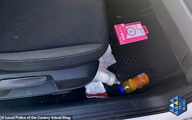 A baby bottle and juice is seen in the footwell of the car