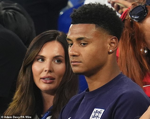 Ollie Watkins sits in the stands with partner Ellie Anderson after the game