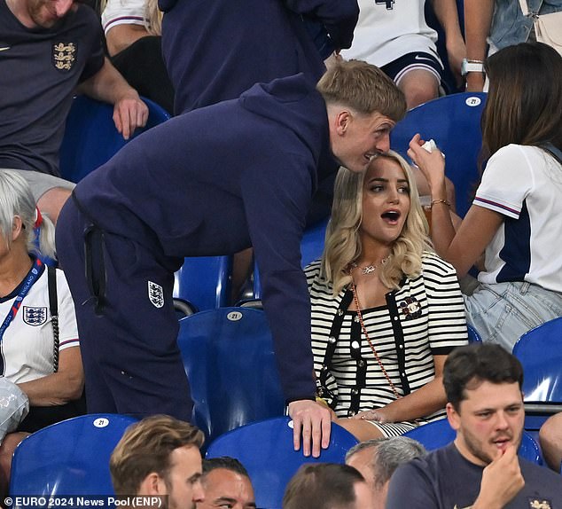 Goalkeeper Jordan Pickford greets Megan Pickford in the crowd in his England tracksuit