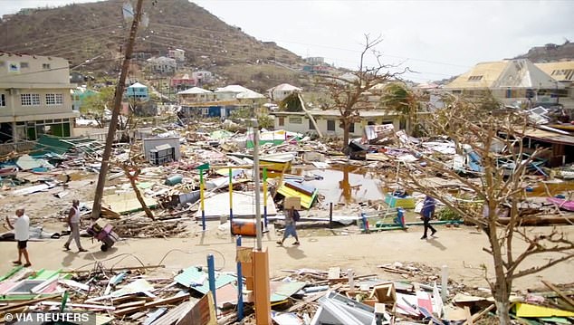 People walk amidst damaged property following the passing of Hurricane Beryl, in Union Island, Saint Vincent and the Grenadines