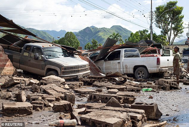 A man looks at damaged vehicles after devastating floods swept through the town after Hurricane Beryl passed off the Venezuelan coast, in Cumanacoa, Venezuela, July 2, 2024