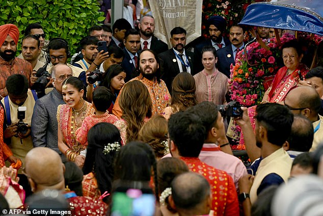 Anant and Radhika (centre) both wore orange, which holds special significance in Hindu culture