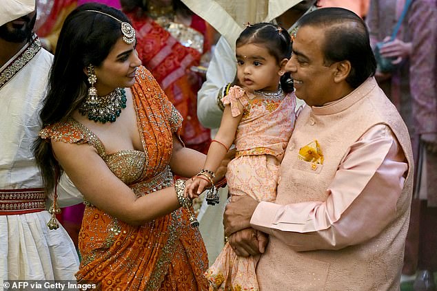 Mukesh is pictured with his daughter, Isha Ambani (left) and his granddaughter at the event on Wednesday