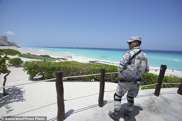 A Mexican soldier stands guard on a beach ahead of Hurricane Beryl's expected arrival, in Cancun, Mexico, Wednesday, July 3, 2024