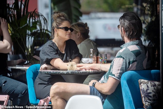 The new parents appeared more loved up than ever and held hands across the table while chatting intently