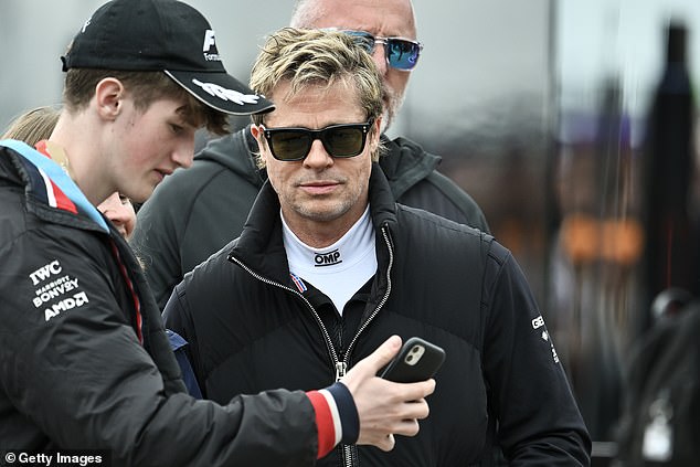 Pitt takes a selfie with a fan while filming scenes for his new Formula 1 movie at Silverstone