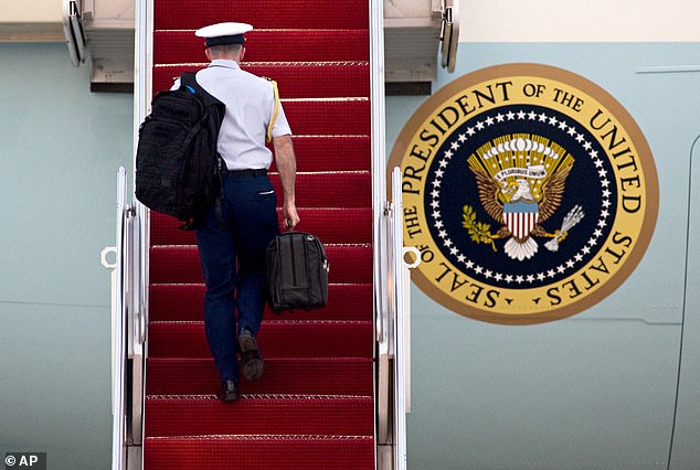 A military aide carries the Presidential Emergency Satchel - aka the 'nuclear football'
