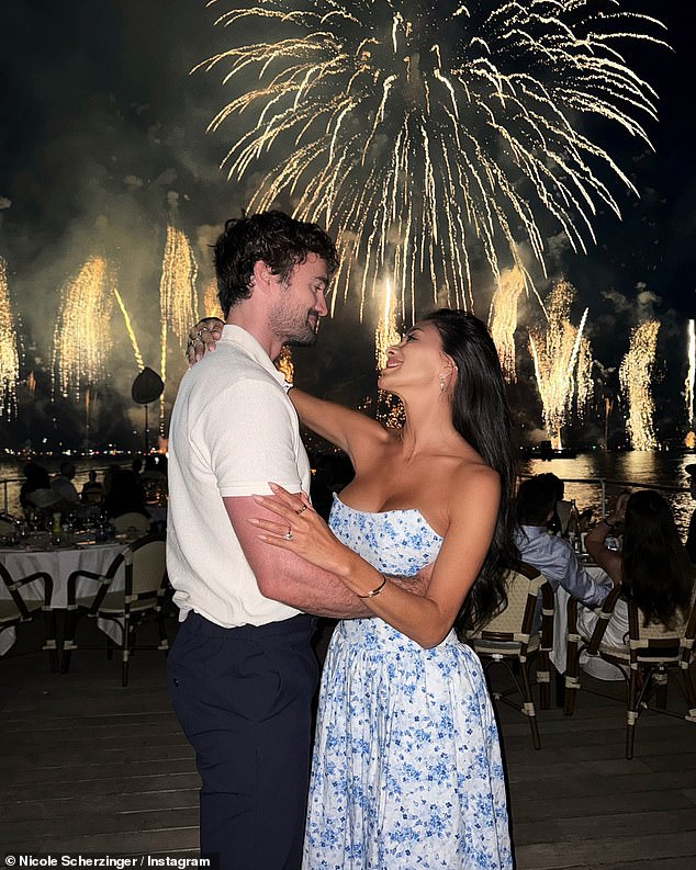 In another sweet snap, the pair looked more loved-up than ever as they gazed into one another's eyes while the sky lit up with gold fireworks