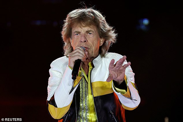 The singer is also seen sporting a yellow, white, and black leather jacket on top of the sparkling one
