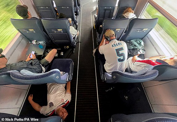 England fans on a train from Hamburg to Dusseldorf ahead of the UEFA Euro 2024, quarter-final match at the Dusseldorf Arena, Germany. Picture date: Saturday July 6, 2024. PA Photo. See PA story SOCCER England. Photo credit should read: Nick Potts/PA Wire.RESTRICTIONS: Use subject to FA restrictions. Editorial use only. Commercial use only with prior written consent of the FA. No editing except cropping.