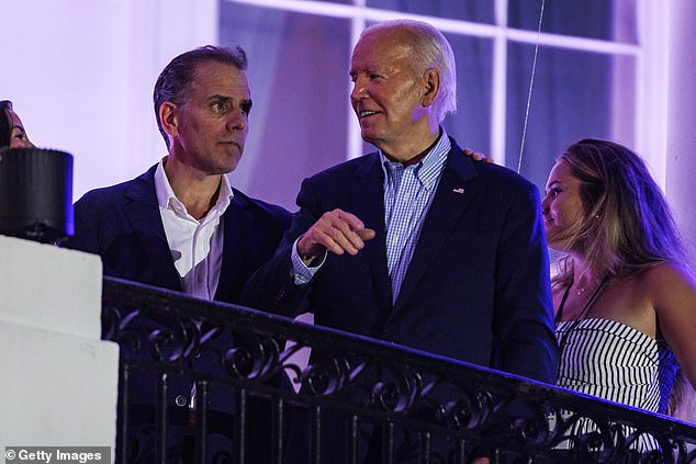 Biden talks to his son, Hunter Biden, after the fireworks on the National Mall with First Lady Jill Biden and Vice President Kamala Harris' husband Doug Emhoff on the White House balcony