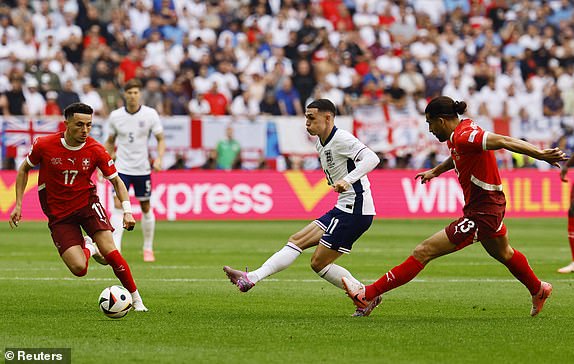 Soccer Football - Euro 2024 - Quarter Final - England v Switzerland - Dusseldorf Arena, Dusseldorf, Germany - July 6, 2024 England's Phil Foden in action with Switzerland's Ricardo Rodriguez and Ruben Vargas REUTERS/Wolfgang Rattay