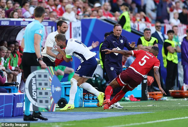 Harry Kane (centre) was sent flying into the England dugout in their clash with Switzerland