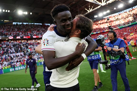 DUSSELDORF, GERMANY - JULY 06: Gareth Southgate, Manager of England men's senior team, celebrates with Bukayo Saka of England following victory during the UEFA EURO 2024 quarter-final match between England and Switzerland at DÃ¼sseldorf Arena on July 06, 2024 in Dusseldorf, Germany. (Photo by Eddie Keogh - The FA/The FA via Getty Images)